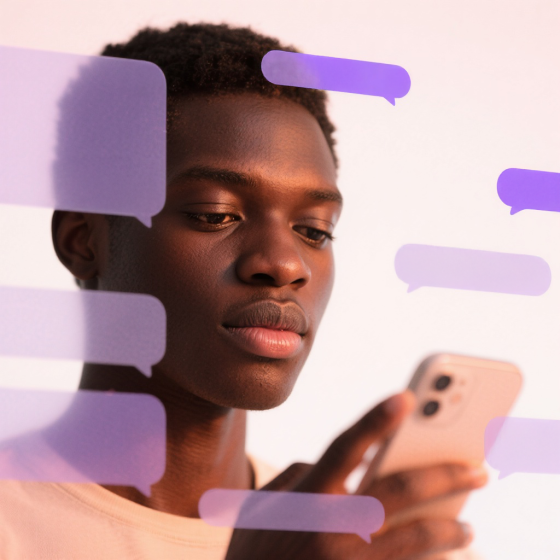 Ein junger Mann hält ein Smartphone und blickt konzentriert darauf; vor ihm sind mehrere halbtransparente Sprechblasen in Lila‑ und Rosatönen eingeblendet.